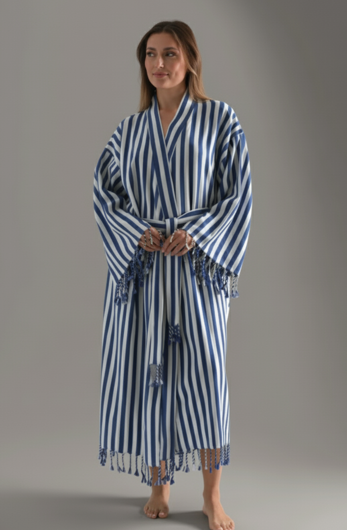 Woman wearing a blue and white striped robe on a gray background