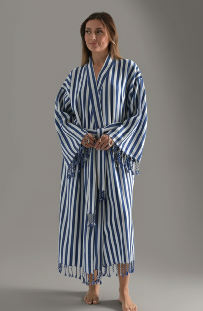 Woman wearing a blue and white striped robe on a gray background